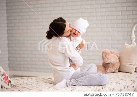 Mother, playing with her toddler boy smiling. 75738747