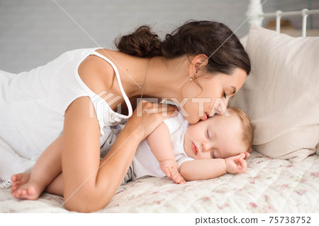 Sweet baby boy sleeping in bed with his mother 75738752