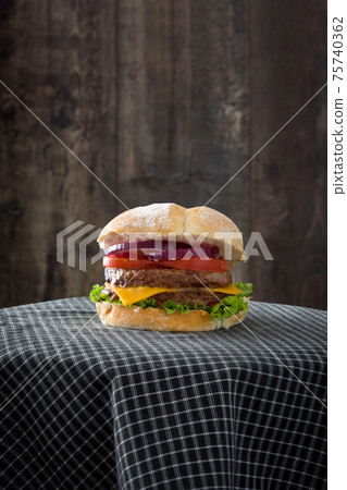 Cheeseburger with beef,tomato, lettuce and onion on wooden table Cheeseburger with beef,tomato, lettuce and onion on wooden table 75740362