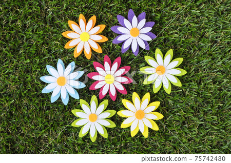 Images of flowers made of colorful felt fabrics. Isolated on the artificial grass. Images of flowers made of colorful felt fabrics. Isolated on the artificial grass. 75742480