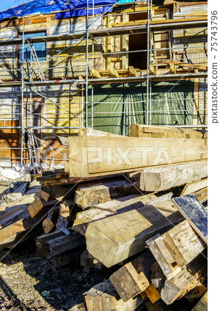 a pile of used wooden building materials on a wooden house restoration site 75743796