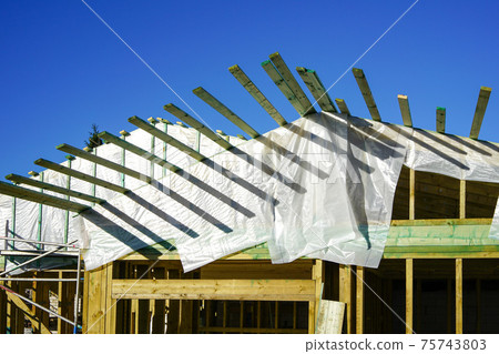 new wooden construction building in the construction process, roofing with waterproofing film 75743803