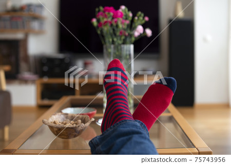 Feet in red socks resting on the table. Feet in red socks resting on the table. 75743956