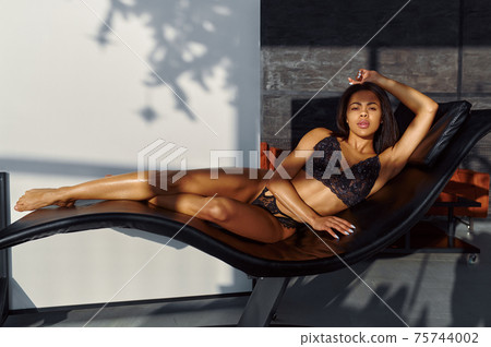 Sexy woman in lingerie posing in leather sunbed 75744002