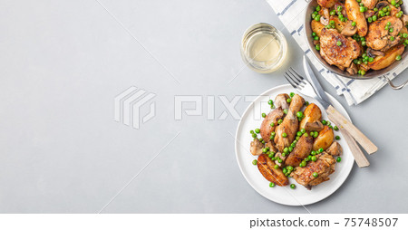 Chicken stew with potatoes, mushrooms and green peas, on a white plate and in metal pot, top view, horizontal, copy space Chicken stew with potatoes, mushrooms and green peas, on a white plate and in metal pot, top view, horizontal, copy space 75748507