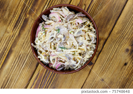 Tasty salad of grated celery root, mushrooms, onions on wooden table. Top view Tasty salad of grated celery root, mushrooms, onions on wooden table. Top view 75748648