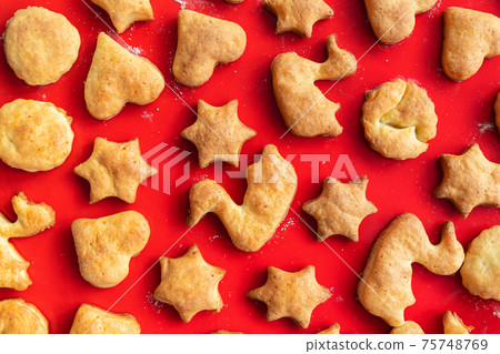 Flat lay top above view of sweet tasty delicious curd ginger cookies baked in hot oven stove on red bright silicone bakery mat at home kitchen. Homemade hot biscuits pattern background 75748769