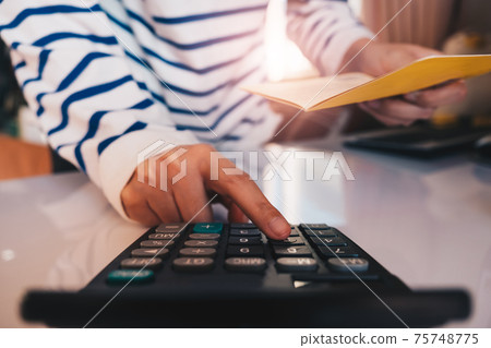 Business hands holding saving account passbook with calculator,  75748775