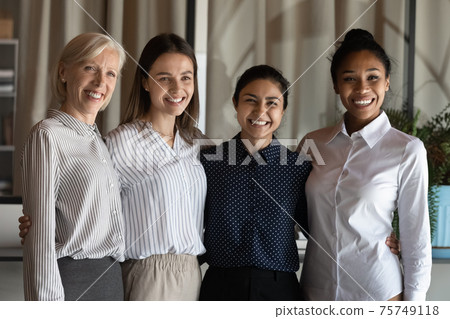 Smiling multiracial female colleagues pose in office Smiling multiracial female colleagues pose in office 75749118