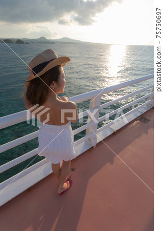 A girl who came for a walk to a bridge on the sea A girl who came for a walk to a bridge on the sea 75750697