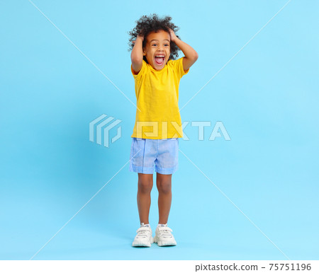 Cheerful black kid touching hair and screaming happily in blue studio Cheerful black kid touching hair and screaming happily in blue studio 75751196