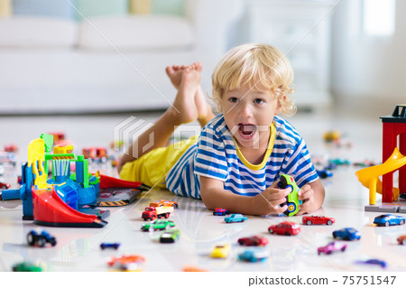 Kids play with toy cars. Children playing car toys Kids play with toy cars. Children playing car toys 75751547