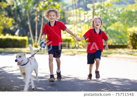 Child walking dog. Kids and puppy. Boy and pet. Child walking dog. Kids and puppy. Boy and pet. 75751548