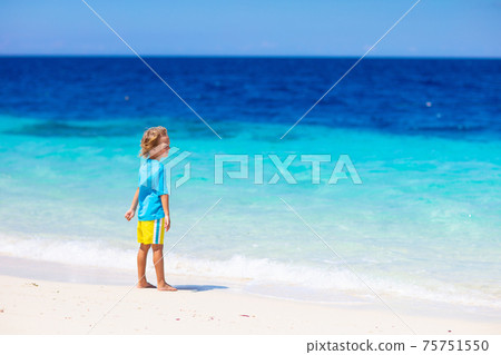 Kids playing on beach. Children play at sea. Kids playing on beach. Children play at sea. 75751550