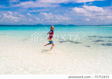 Kids playing on beach. Children play at sea. Kids playing on beach. Children play at sea. 75751655