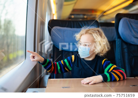 Kids travel by train in face mask. Virus outbreak. Kids travel by train in face mask. Virus outbreak. 75751659
