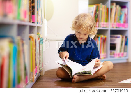 Child in school library. Kids reading books. Child in school library. Kids reading books. 75751663