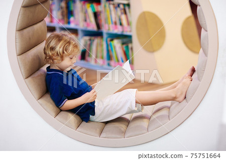 Child in school library. Kids reading books. Child in school library. Kids reading books. 75751664