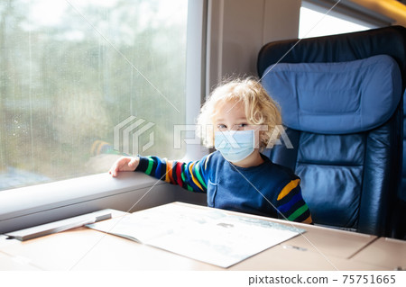 Kids travel by train in face mask. Virus outbreak. Kids travel by train in face mask. Virus outbreak. 75751665