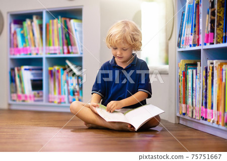 Child in school library. Kids reading books. Child in school library. Kids reading books. 75751667