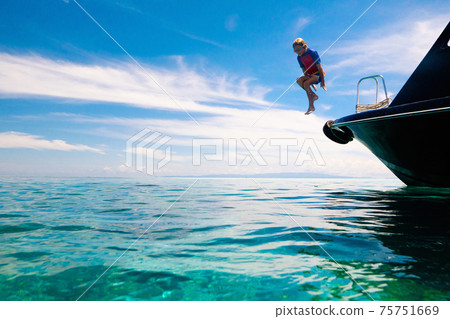 Child jumping into sea water. Yacht vacation. Child jumping into sea water. Yacht vacation. 75751669