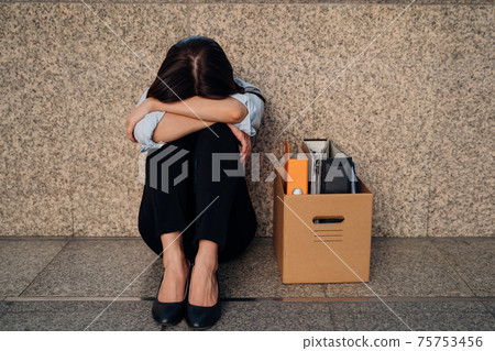 Young woman with box of stuff after losing job Young woman with box of stuff after losing job 75753456