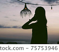 Silhouette of a woman floating in the sunset 75753946