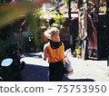 A woman walking in the back alley of Bali 75753950