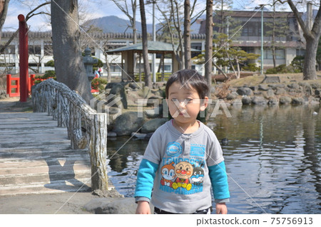 一個男孩在一個池塘的公園裡散步 75756913