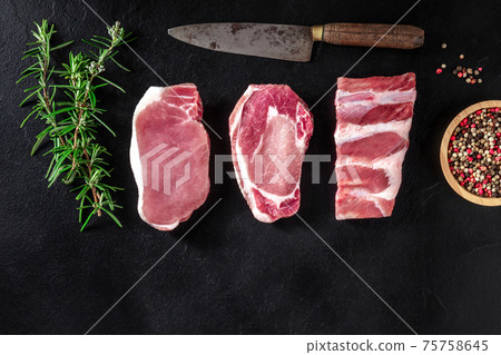 Pork meat, various cuts, shot from above on a black background Pork meat, various cuts, shot from above on a black background 75758645