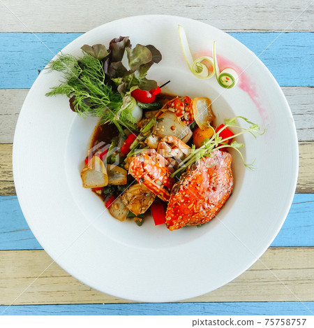Crab with sauce with stewed onions on white plate Crab with sauce with stewed onions on white plate 75758757