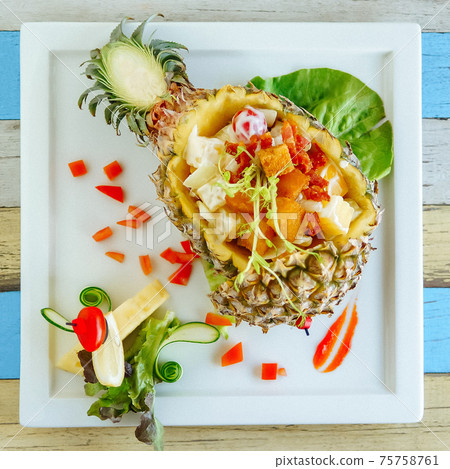 Salad with chopped fried bacon in pineapple cut in half Salad with chopped fried bacon in pineapple cut in half 75758761