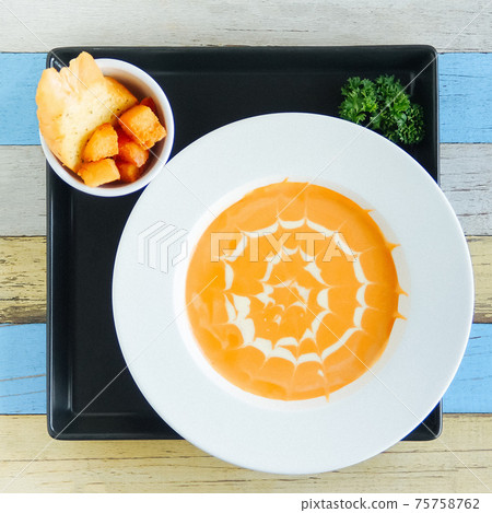 Pumpkin cream soup with white pattern and toasted white bread Pumpkin cream soup with white pattern and toasted white bread 75758762