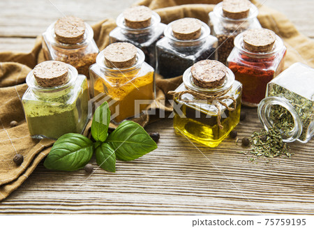 Jars with dried herbs, spices on the table 75759195