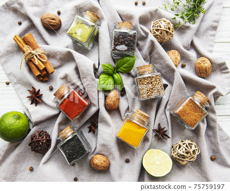 Jars with dried herbs, spices on the table 75759197
