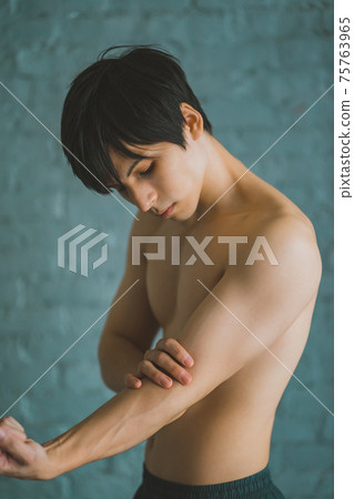 一個男人觸摸手臂的肌肉 75763965