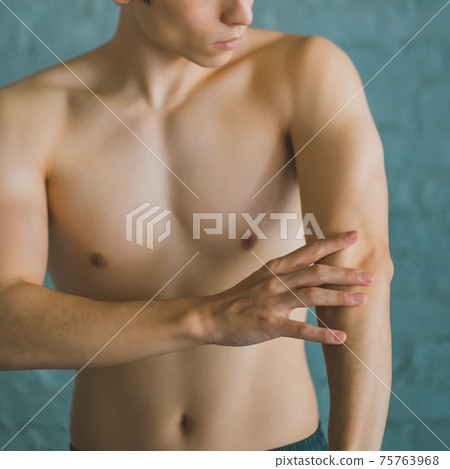 一個男人觸摸手臂的肌肉 75763968