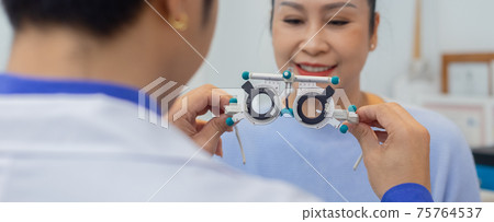 Close up messbrille eye test glasses in a hand of optometrist with blur women background. Close up messbrille eye test glasses in a hand of optometrist with blur women background. 75764537