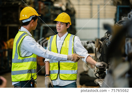 Teamwork engineers, Worker wear uniform and helmet talking in warehouse. 75765082
