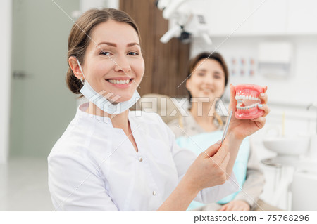 Healthy, beautiful smile. A portrait of a doctor holding an arti 75768296
