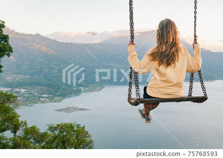 Young woman looking at amazing tropical lake in mountains Young woman looking at amazing tropical lake in mountains 75768593