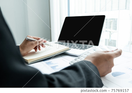 The hands of a male businesswoman use the calculator are analyzing and calculating the annual income and expenses in a financial graph that shows results To summarize balances overall in office The hands of a male businesswoman use the calculator are analyzing and calculating the annual income and expenses in a financial graph that shows results To summarize balances overall in office 75769157