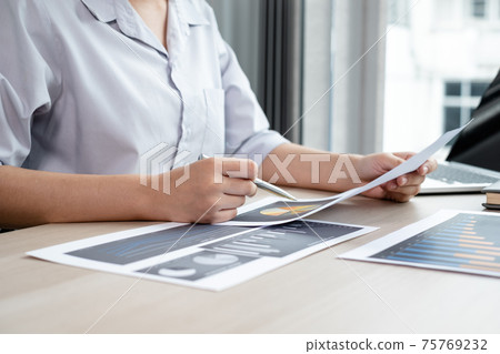The hands of a male businesswoman are analyzing and calculating the annual income and expenses in a financial graph that shows results To summarize balances overall in office The hands of a male businesswoman are analyzing and calculating the annual income and expenses in a financial graph that shows results To summarize balances overall in office 75769232