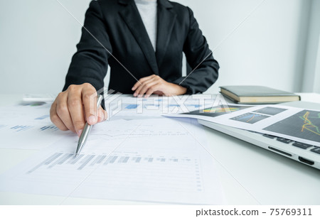The hands of a male businesswoman are analyzing and calculating the annual income and expenses in a financial graph that shows results To summarize balances overall in office The hands of a male businesswoman are analyzing and calculating the annual income and expenses in a financial graph that shows results To summarize balances overall in office 75769311