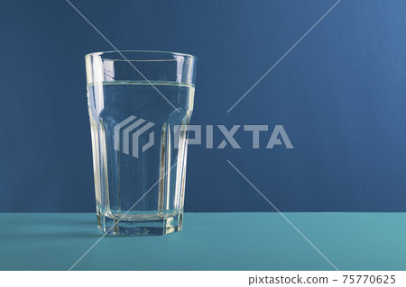 Glass of water fresh and pure water on blue background. Glass of water fresh and pure water on blue background. 75770625