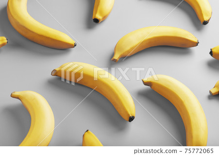 Geometric pattern of yellow bananas on a gray background in the Fashionable colors of 2021. Geometric pattern of yellow bananas on a gray background in the Fashionable colors of 2021. 75772065