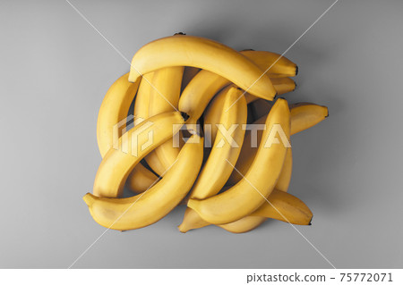 Fresh bunch of yellow bananas isolated on a Gray background Trendy colors of 2021 Fresh bunch of yellow bananas isolated on a Gray background Trendy colors of 2021 75772071
