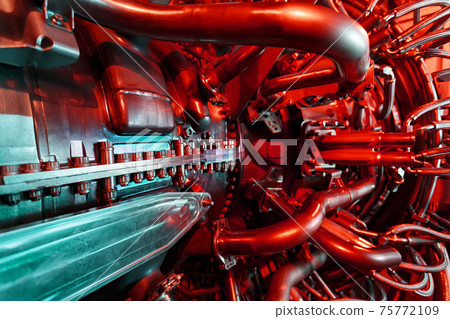 A modern gas turbine aircraft engine in a futuristic red-green light. A modern gas turbine aircraft engine in a futuristic red-green light. 75772109
