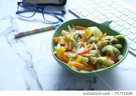 bowl of fresh salad on office desk bowl of fresh salad on office desk 75772686