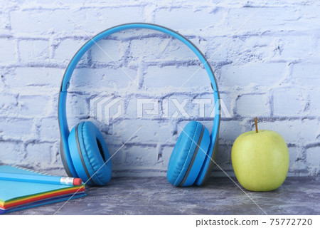 Audio book concept. Headphones and notepad on white background Audio book concept. Headphones and notepad on white background 75772720